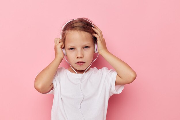 Portrait of cute girl with arms crossed standing against pink background