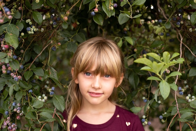portrait of cute girl with bangs amidst plants at park
