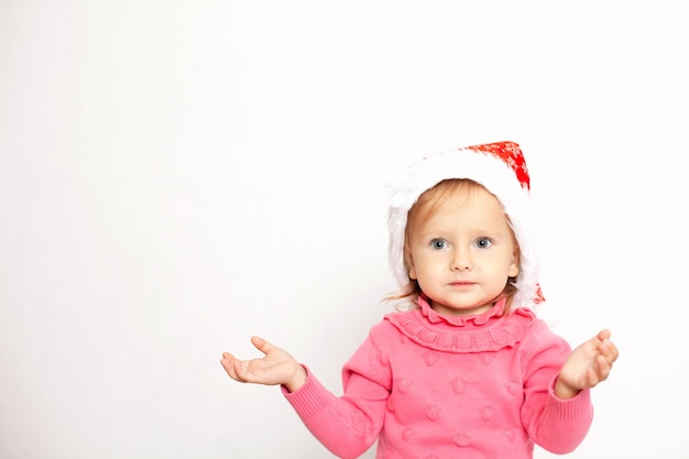 クリスマスの帽子の青い目を持つかわいい女の子の肖像画テキストの白い背景スペース