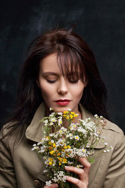 Портрет милой девушки с букетом полевых цветов
