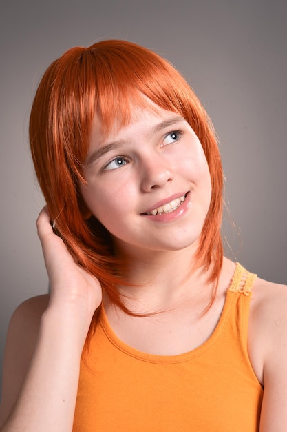 스튜디오에서 포즈를 취하는 빨간 머리를 가진 귀여운 소녀의 초상화