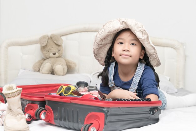 portrait of cute girl with travel accessories costumes. luggage, camera, sunglasses, clothes in suit