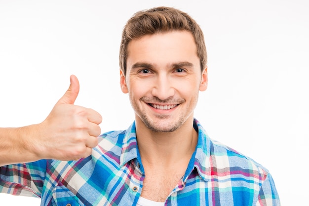 Portrait of a cute handsome young man showing thumb up