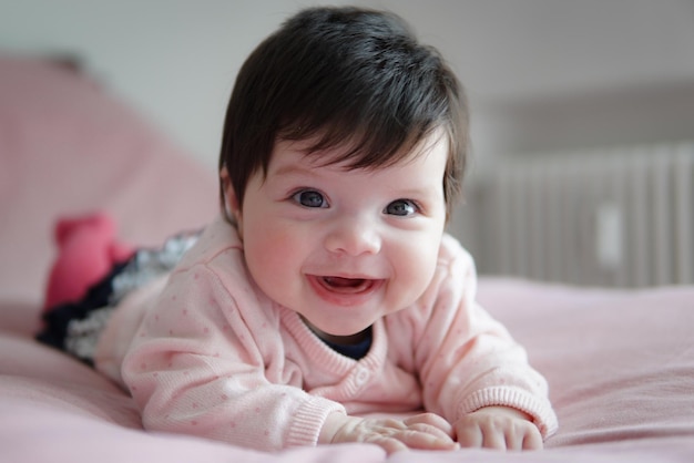 Foto ritratto di una bambina carina e felice sul letto a casa