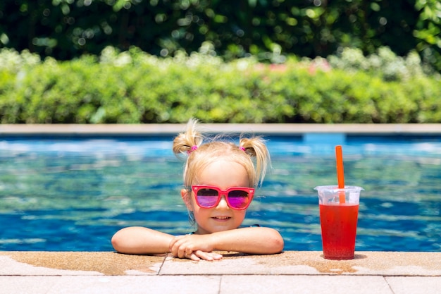 Портрет милая счастливая маленькая девочка с удовольствием в бассейне