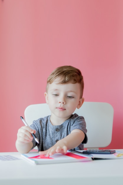 自宅でかわいい子供男の子の肖像画は宿題を作る