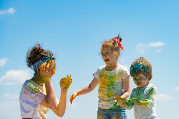 Photo portrait of a cute kids painted in the colors of holi festival