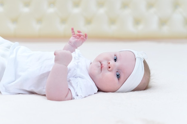 Portrait of cute little baby girl against light background