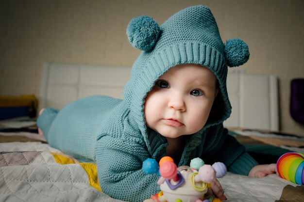 Portrait of a cute little baby girl in a knitted hat and warm clothes