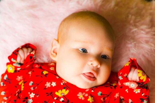 Portrait of a cute little baby girl lying on the bed