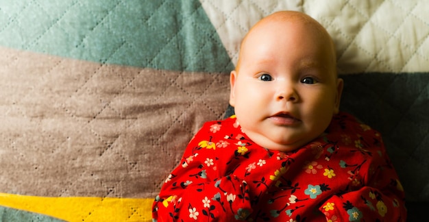 Portrait of a cute little baby girl lying on the bed