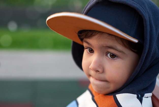Photo portrait of a cute little boy in baseball cap and sportswear