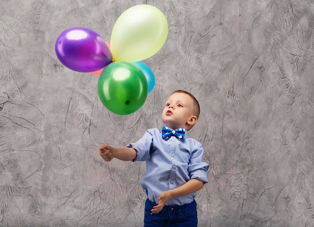 Portrait of a cute little boy holding balloons