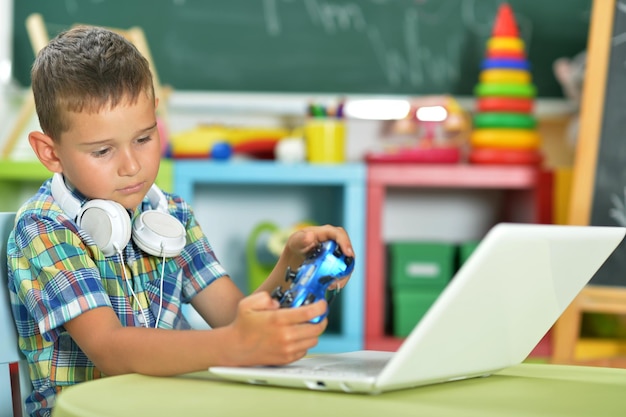 Портрет милого маленького мальчика с ноутбуком