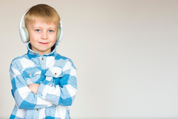 Ritratto di un ragazzino carino con le cuffie su uno sfondo bianco