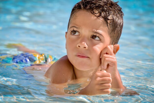 Foto ritratto di un bambino carino che nuota in una piscina