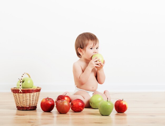 Portrait of a cute little child with apples indoor