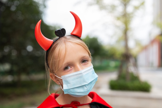 Photo portrait of cute little girl in costume of evil