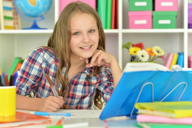 Portrait of a cute little girl doing homework