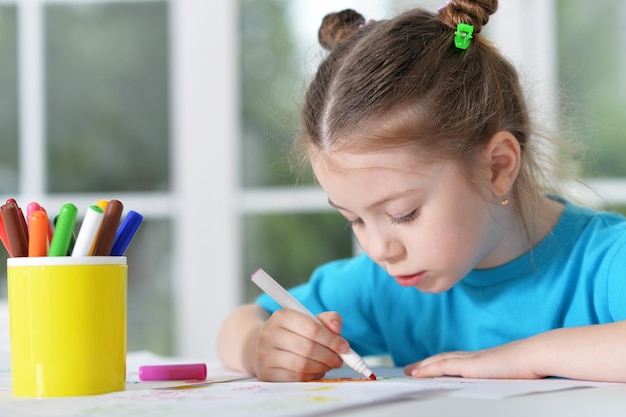 Portrait of a cute little girl drawing, close up