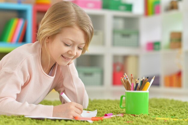 Portrait of cute little girl drawing at home