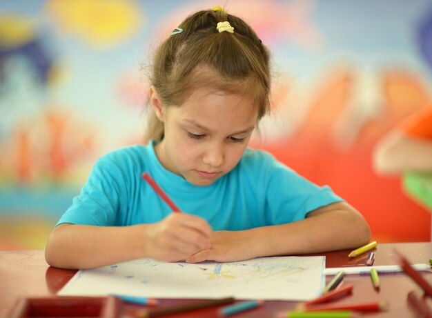 Photo portrait of a cute little girl drawing