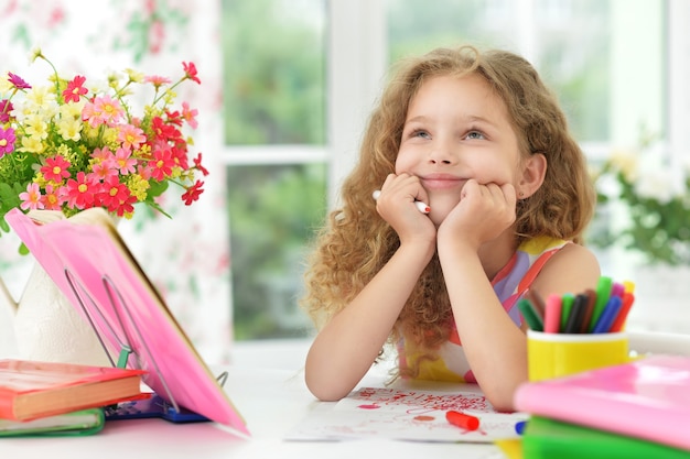 Portrait of a cute little girl dreaming about something