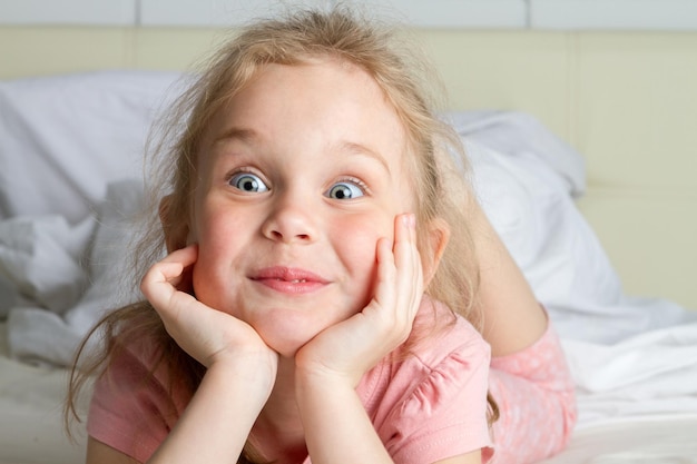 Portrait of cute little girl dreaming in bed