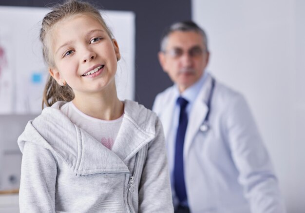 Portrait of a cute little girl and her doctor at hospital