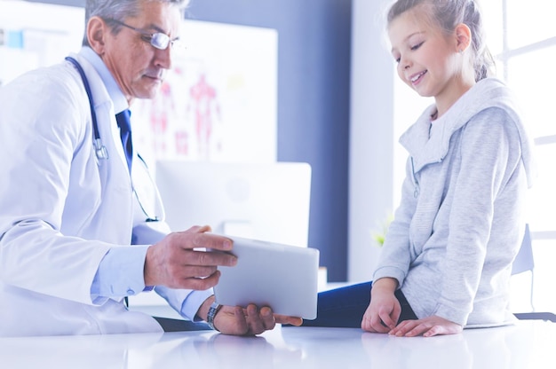 Portrait of a cute little girl and her doctor at hospital