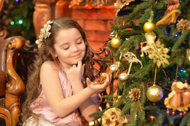 Portrait of a cute little girl near Decorated Christmas tree