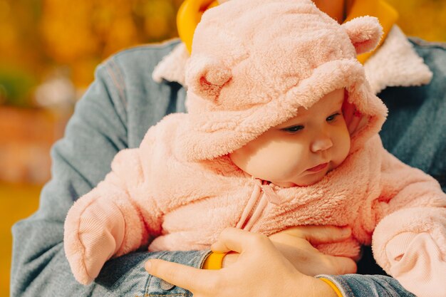 Portrait of a cute little girl in a pink coat with a hood