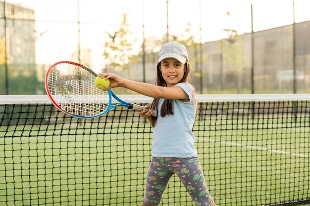 Portrait of a cute little girl playing tennis