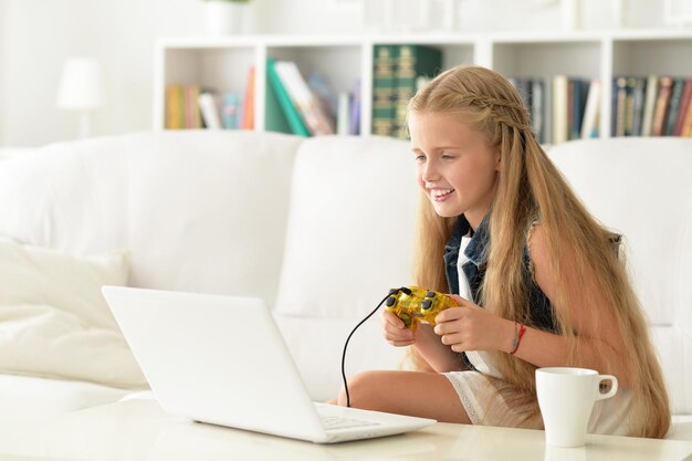 Portrait of a cute little girl playing video game