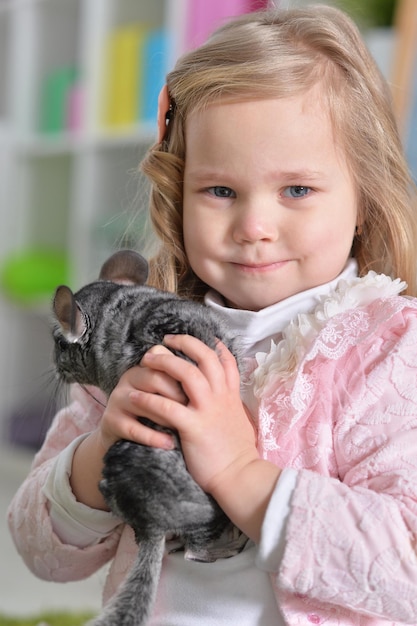 Portrait of a cute little girl playing with chinchilla