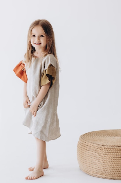 Portrait of a cute little girl posing for a photo in a bright studio The girl laughs and has fun