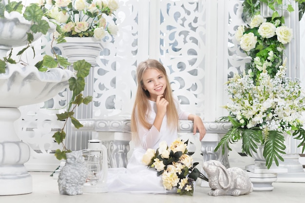 Portrait of cute little girl  posing with flowers