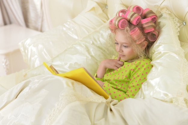 Portrait of a cute little girl reading a book