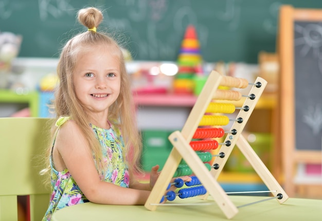 Portrait of cute little girl sitting at table