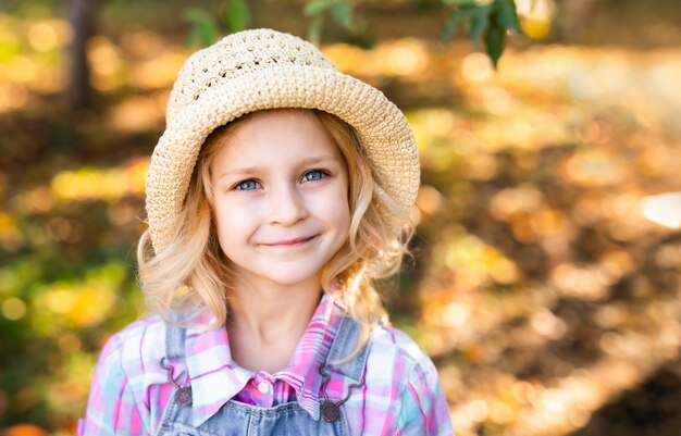 Ritratto della bambina sveglia in piccolo cappello di paglia