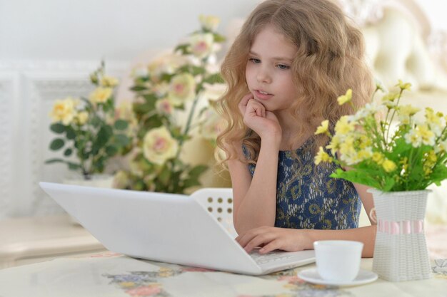 Ritratto di una bambina carina che usa il laptop