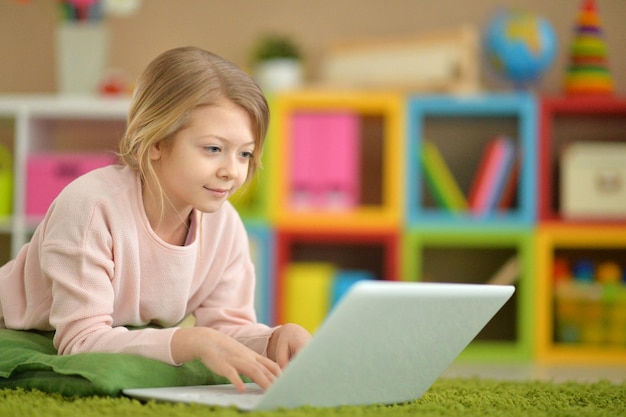Portrait of cute little girl using modern laptop