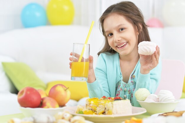Portrait of cute little girl with food at kitchen