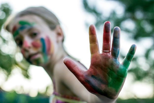 Ritratto di una ragazza carina con il viso dipinto e le mani