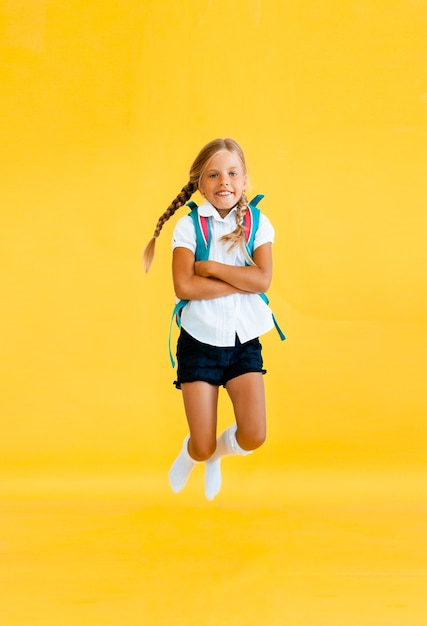 Portrait of a cute little girl on a yellow background. 