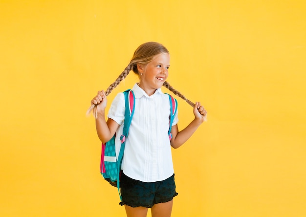 Portrait of a cute little girl on a yellow background. 