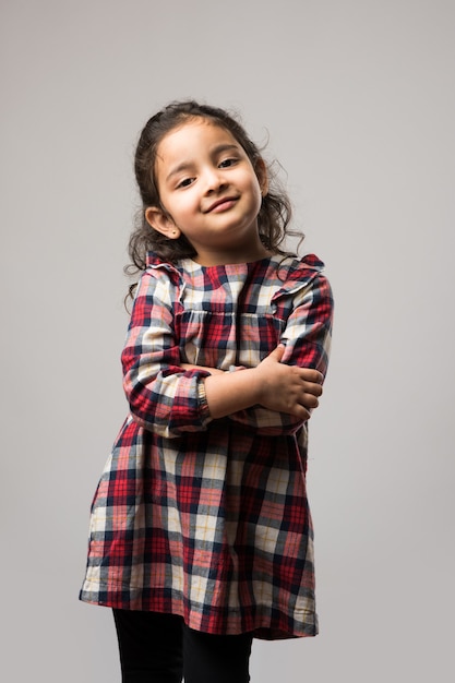 白い背景の上に孤立して立っているかわいいインドの少女モデルの肖像画