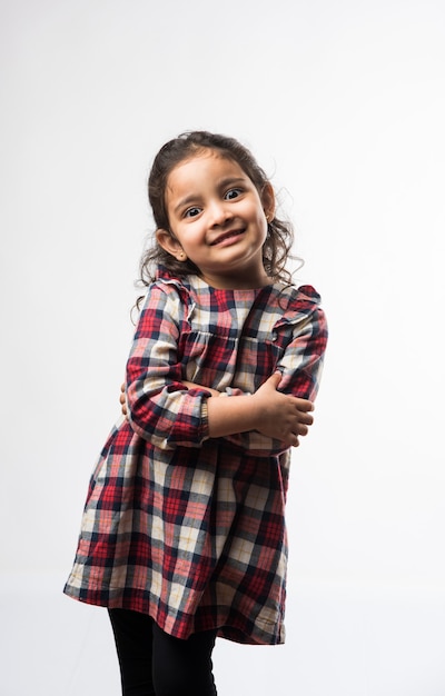 白い背景の上に孤立して立っているかわいいインドの少女モデルの肖像画