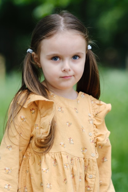 Portrait of a cute little preschool girl in a spring park