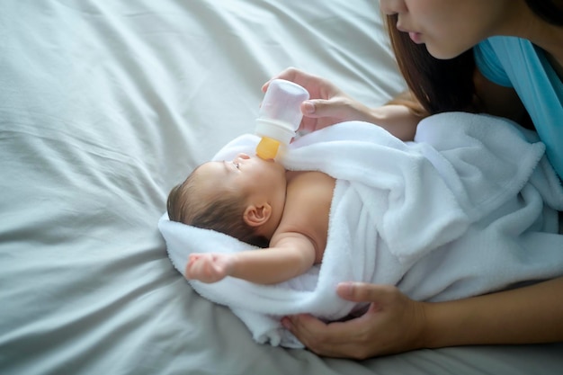 牛乳瓶を飲むかわいい新生児の肖像画